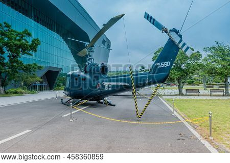 Jeju City, South Korea; June 20, 2022: Bell Uh-1b Helicopter On Pavement At Museum Under Cloudy Sky.