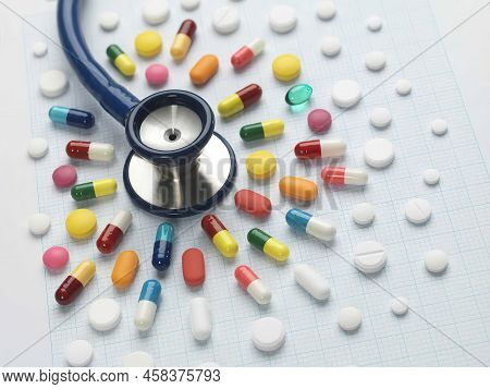 Stethoscope And Various Pills On A Blue Background. Medicene Concept