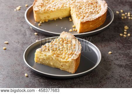 Piece Of Italian Grandma's Pie With Custard And Pine Nuts Close-up In A Plate On The Table. Horizont