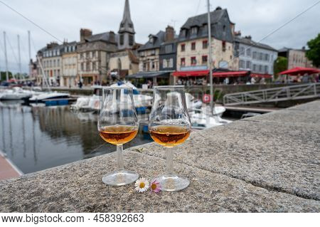 Tasting Of Apple Calvados Drink In Old Honfleur Harbour With Boats And Old Houses On Background, Nor