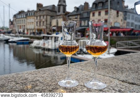 Tasting Of Apple Calvados Drink In Old Honfleur Harbour With Boats And Old Houses On Background, Nor