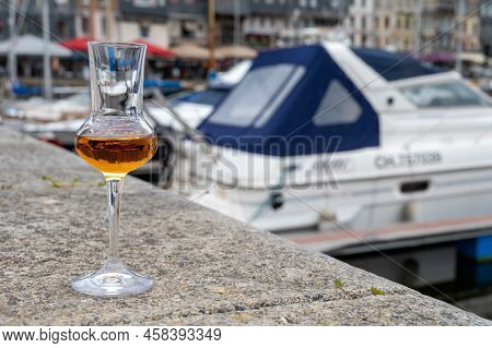Tasting Of Apple Calvados Drink In Old Honfleur Harbour With Boats And Old Houses On Background, Nor