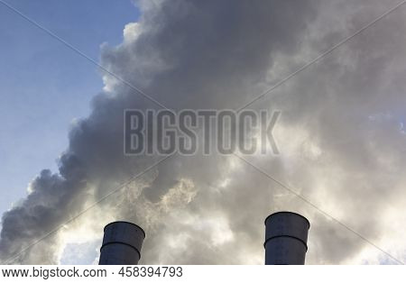 Air Pollution By Smoke Coming Out Of Two Factory Chimneys. Close-up From Below Of Smoke Coming Out O