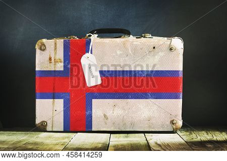 Old Suitcase In The Colors Of The Faroe Island Flag. Travels. Signs And Symbols. Background.
