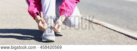 Low Angle Of Woman Runner Tying Laces Before Training On Fresh Air In Park. Going To Tun Marathon In