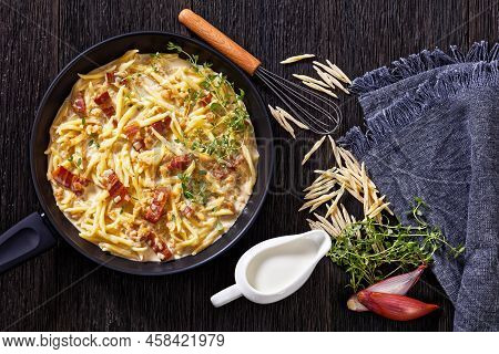 Capunti Pasta In Cream Pecorino Cheese And Pancetta Sauce On Pan On Dark Wooden Table With Ingredien