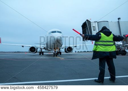 Aircraft Marshalling At The Aiport Apron. Passenger Airplane Meeting