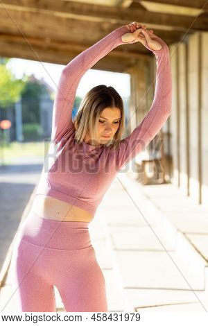 Beautiful Young Blonde Fitness Woman Wearing Pink Sports Clothes Stretching And Full Body Warming Up