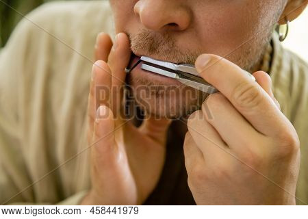 Cropped View Of Man Playing Jews Harp Outdoors