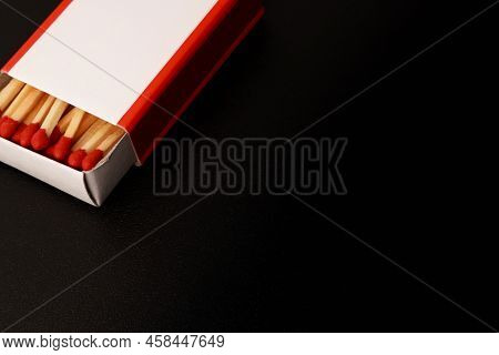 Black Blank Background With An Open Matchbox In The Corner Of The Image. Matches With Red Sulfur Hea