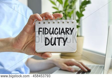 Fiduciary Duty Text Is Written On Paper. Business Woman Holding A Sheet With Fiduciary Duty An Inscr