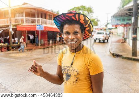 Black Skinned Latino Gay With Colorful Hat Smiling And Looking At Camera