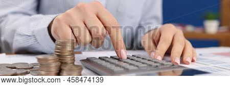 Close-up Of Female Count On Silver Calculator, Cash Coins On Office Desk. Calculation Of Income, Tax