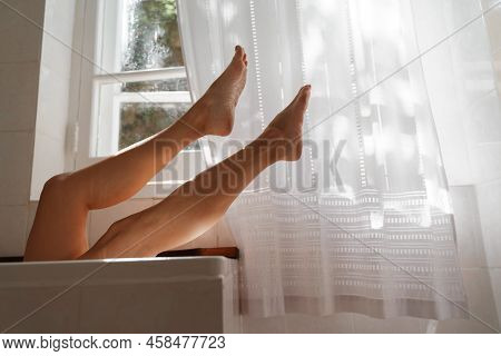 A Beautiful Mature Woman Massages Her Legs In A Bath With Candles In A Cozy And Comfortable Atmosphe