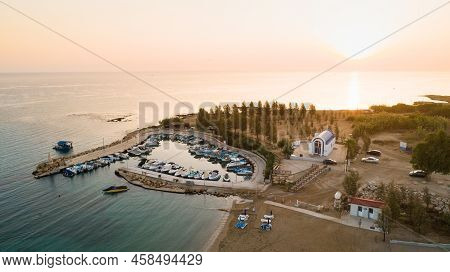 Aerial View Of Coastline Sunset And Landmark White Washed Chapel At Agia Triada Beach, Protaras, Fam