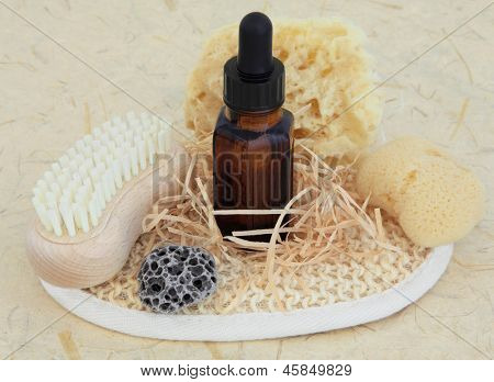 Aromaterapi æteriske olie flaske, natursvampe, pimpsten, nail brush og eksfolierende krat over mo