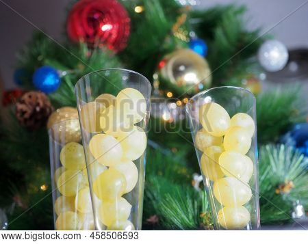 Three Glasses Of Champagne With Twelve Grapes Against The Background Of A Christmas Tree. It Is A Sp