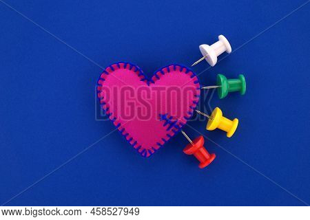 Heart Pain, Medical Concept With Multicolor Push Pins Stuck Into A Felt Heart Symbolizing Pain Inten