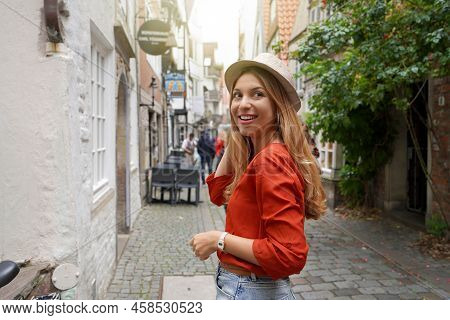 Portrait Of Smiling Traveler Woman In Schnoor Neighborhood, Bremen, Germany