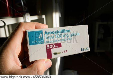 Paris, France - May 24, 2022: Pov Male Hand Holding Package With Amoxicilline Pills Manufactured By 