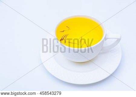 Tea From Saffron Stamens In A White Cup On A White Background.