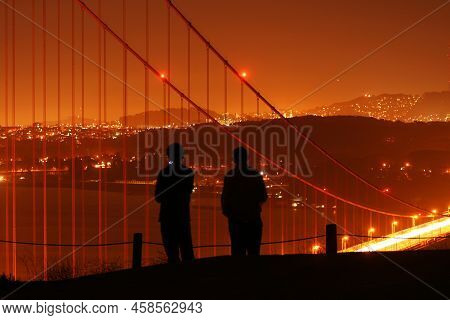 Silhouete Of A Couple While They Comtemplate The View Of The City Of San Francisco Throught The Cabl