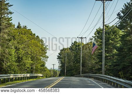 Country Main Road Fading Into The Horizon Distance On A Blue Sky Day, Maine, Usa