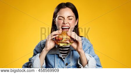 Girl Bites Cheeseburger With Pleasure. Woman Eating Hambuger, Order Burger For Takeaway Food Deliver