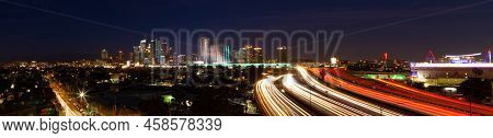 Los Angeles, Ca - June 20 2022:  Los Angeles Skyline At Night With Car Trails On The Freeway Leading