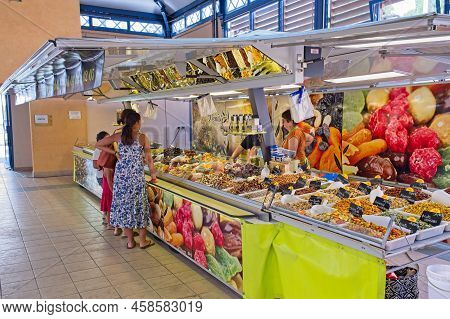 Limoux Aude France 07.22.22 Indoor Market Stall Selling Dried Fruits And Nuts. Young Women In A Summ