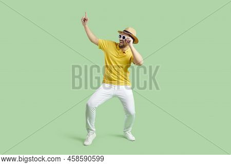Cheerful Funny Man In Good Mood Having Fun Dancing Isolated On Light Green Background.