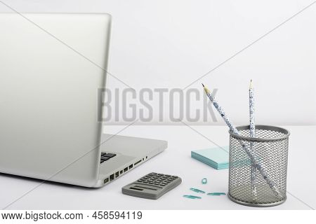 Lap Top, Case With Pencils, Calculator, Paperclips And Sticky Notes Placed On Desk. Computer, Pens, 