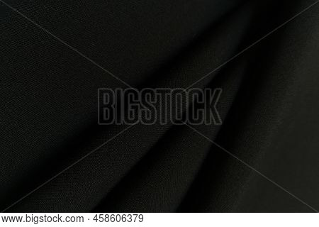 Black Crumpled Or Wavy Fabric Texture Background. Abstract Linen Cloth Soft Waves. Gabardine Wool Fa