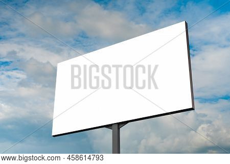 Mock Up - Blank White Billboard Or Large Advertising Display Against Blue Sky With White Clouds. Con
