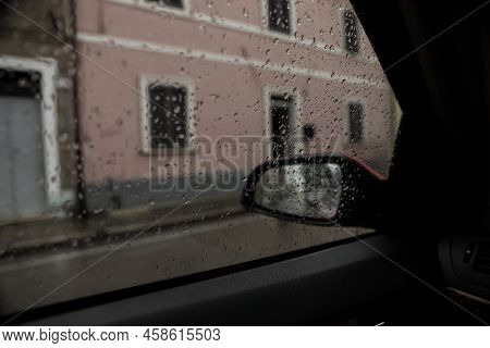 Rainy Weather In City, View Through Car Window Covered With Drops
