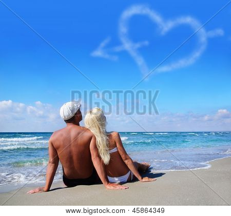 Love Concept - Couple On Sea Beach Look At Cloudy Heart