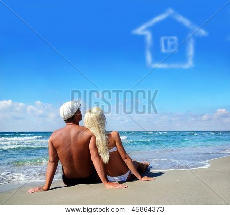 Young Couple On Sea Sand Beach Dreaming About The Own Home