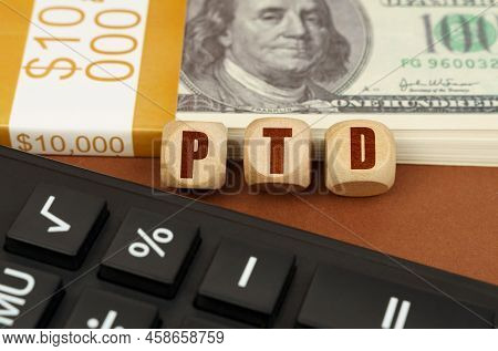 Business Concept. On The Table Are Dollars, A Calculator And Cubes With The Inscription - Ptd
