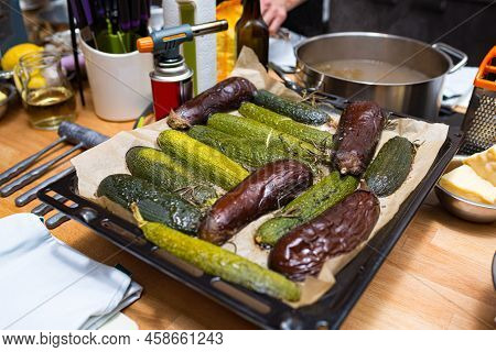 Eggplant And Zucchini Halves Baked In The Oven On An Iron Tray And Baking Paper. Kitchen Background.