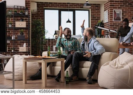 Multiethnic Team Of People Doing Highfive Gesture After Winning Video Games Play On Television Conso