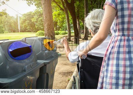 Asian Senior Woman Hand Holding Plastic Bottle,putting Plastic Water Bottle In Recycling Bin,elderly