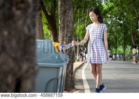 Asian Little Child Girl Hand Holding Plastic Bottle,putting Plastic Water Bottle In Recycling Bin,to