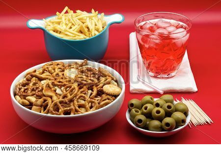 Italian Aperitive: Glass Of Frozen Cocktail With Green Pitted Olves, Fries And Salted Pretzels Snack