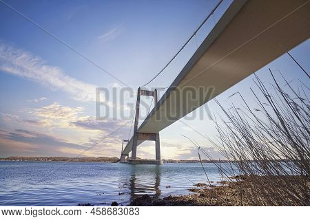 Bridge In A Beautiful Sunset With Reeds Bny The Calm Water In The Afternoon