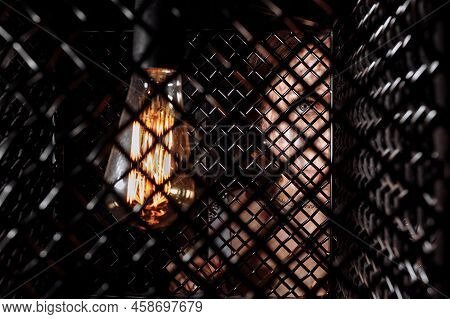 Caucasian Woman's Portrait In Retro Light Bulb. Beautiful Female Model Is Looking In Camera Behind M