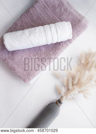 Pink And White Twisted Towel With Dried Flowers On The White Background.