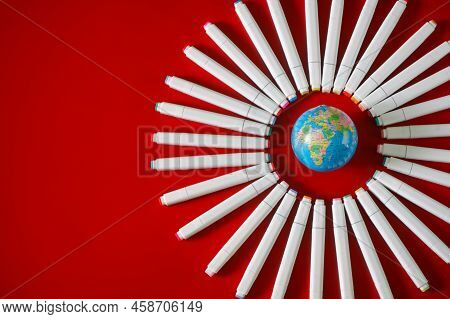 Lot Of Multi-colored Felt-tip Pens Or Markers And A Globe In A Circle On A Red Background. Concept O