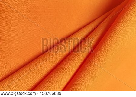 Orange Crumpled Or Wavy Fabric Texture Background. Abstract Linen Cloth Soft Waves. Gabardine Wool F