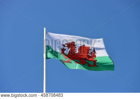 Wales Flag - Red Dragon Passant On White And Green - Bold And Proud Floating In The Wind Against Blu