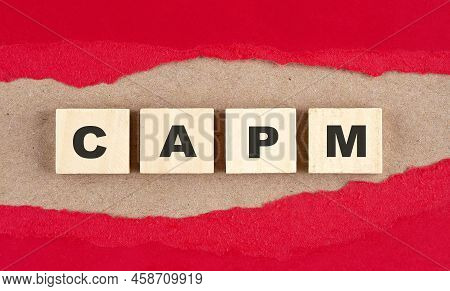 Capm Word On A Wooden Cubes On Red Torn Paper